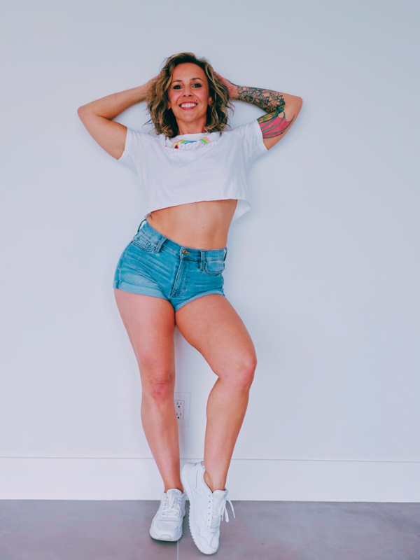 A woman standing in front of a white wall.